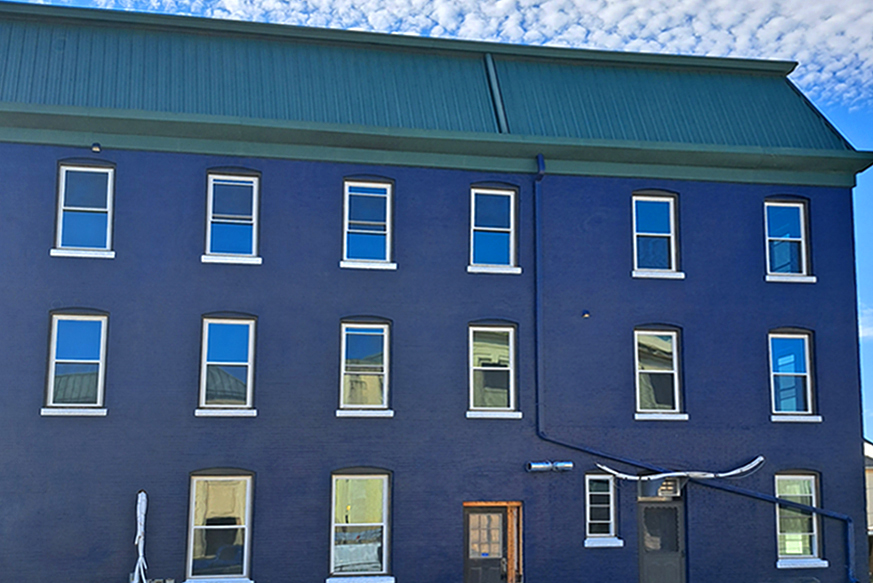 Blue exterior with many windows and custom white trim